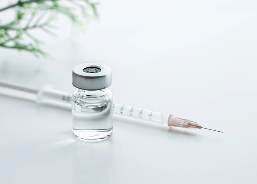 Medical vial and syringe with needle on white surface for vaccination or immunization treatment