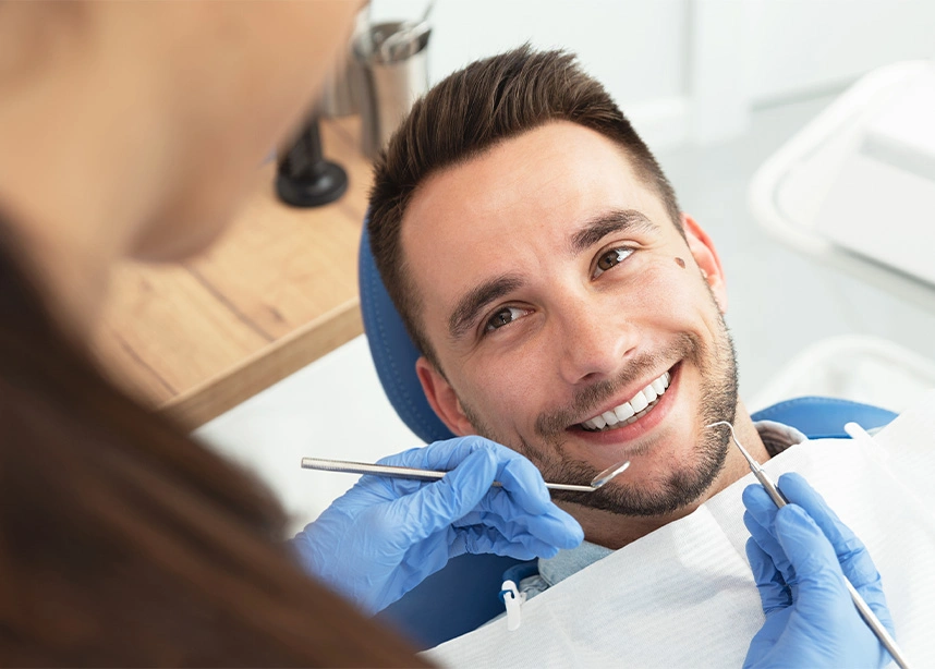 Patient smiling at dentist during dental examination in modern clinic