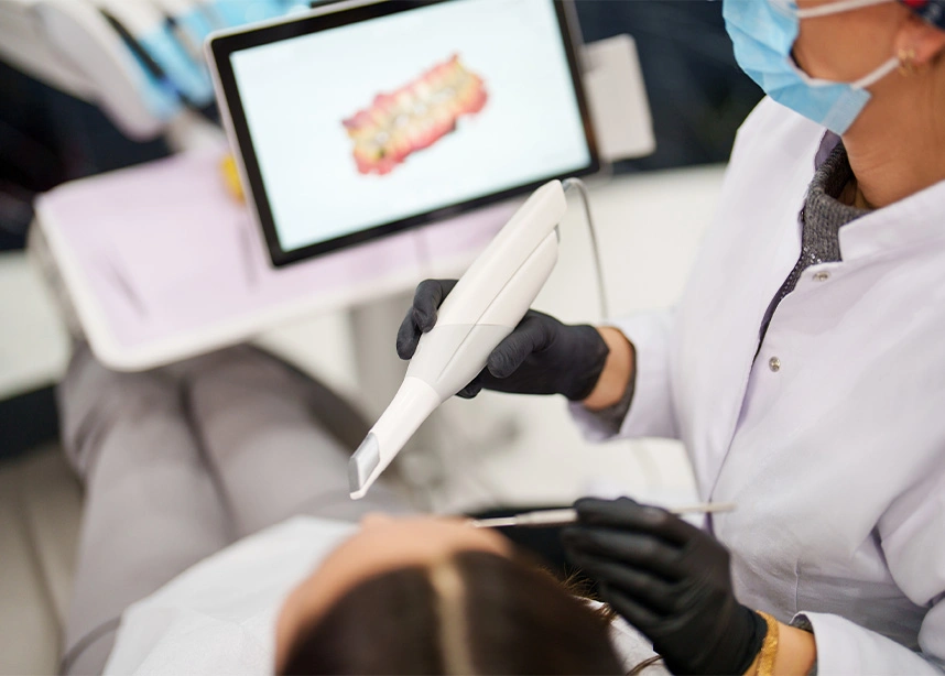 Dentist examining patient's teeth while wearing protective gloves and mask in modern dental clinic